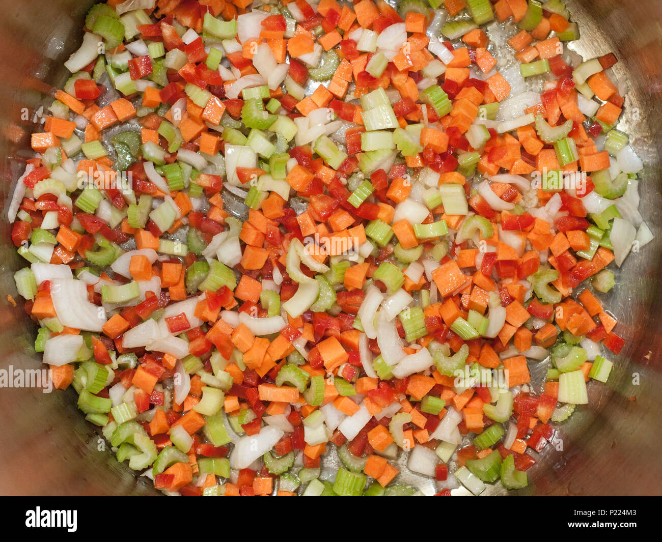 Diced vegetables frying in the bottom of a pot. Stock Photo