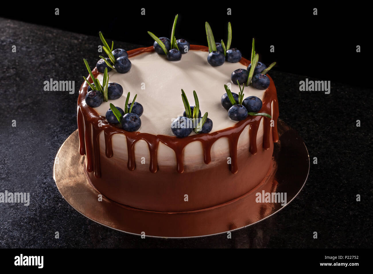 Chocolate cake with blueberries on a black background, decorated with ...