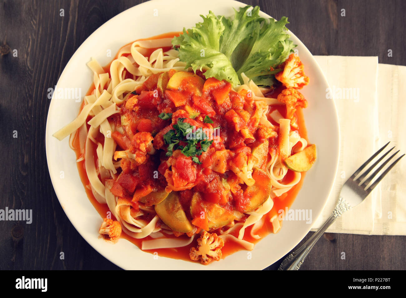 Ribbon pasta with Arrabiata sauce. Close up. Mediterranean dish. Tagliolini pasta with vegetables. Cauliflower, courgette and tomato stew. Italian cui Stock Photo