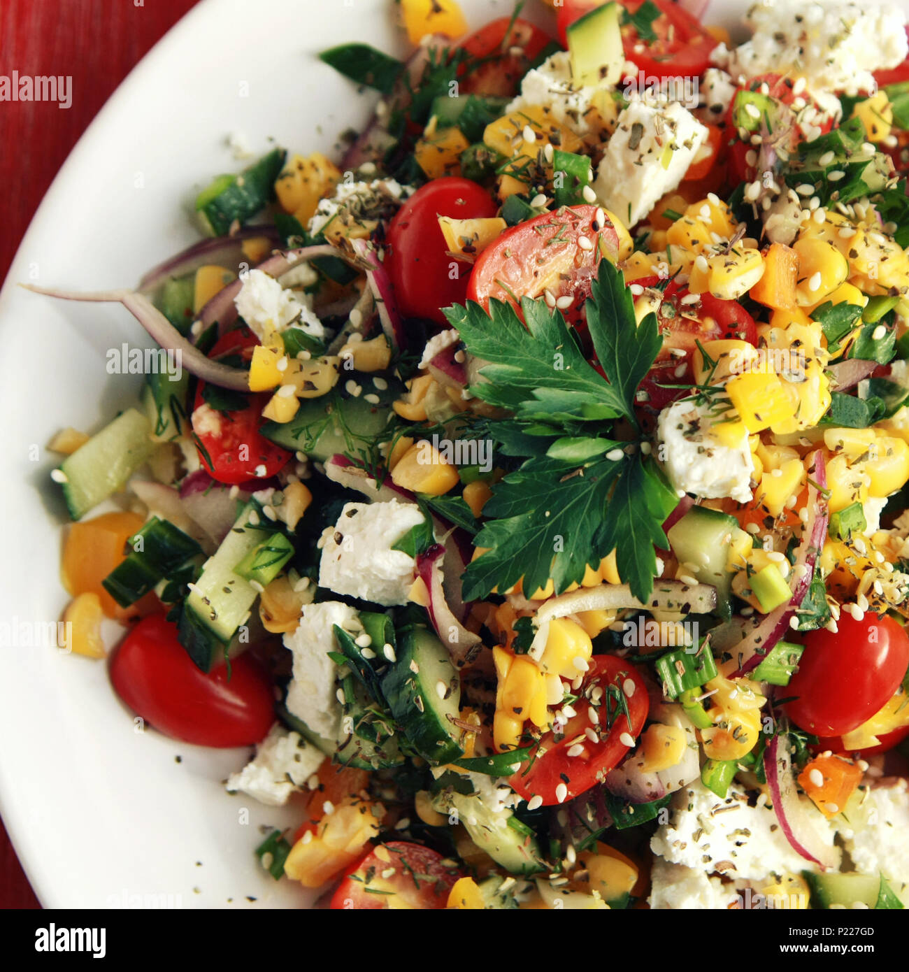 Colorful vegetable mix. Simple low calories salad. Cherry tomatoes, sweet corn, cucumber, bell pepper and cottage cheese. Weight loss dish. European c Stock Photo