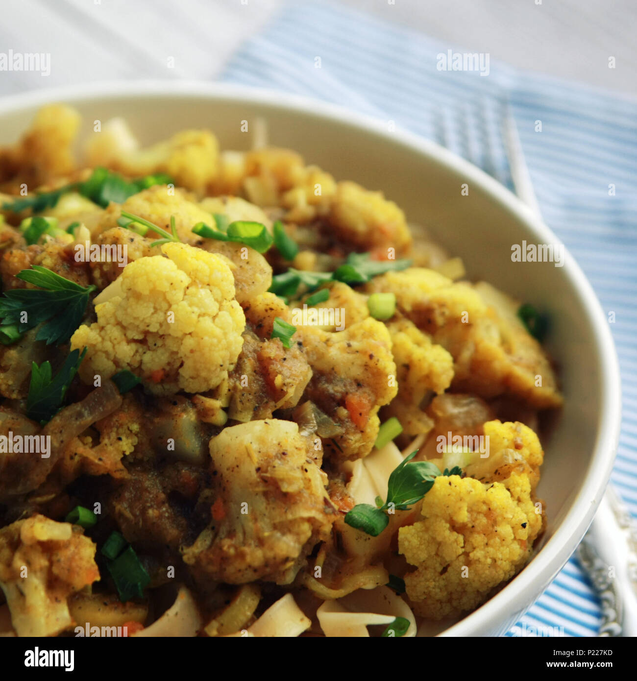 Cauliflower stew with curry. European cuisine. Ribbon pasta topped with vegetables. Vegan lunch. Simple homemade dishes. Vegetables and pasta. Main co Stock Photo