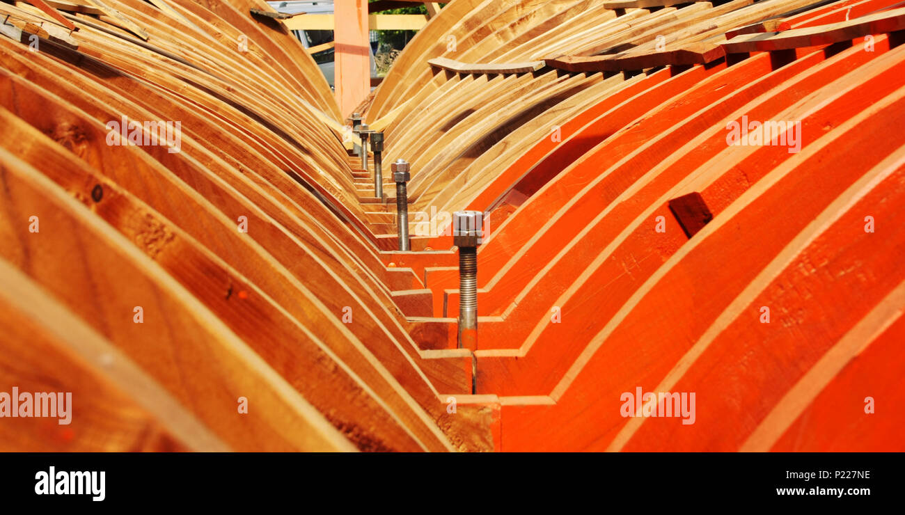 Building a boat. Under construction. Toned photo. The wooden keel beams. Orange wood. Colorful image. Traditional methods. Turkey. Stock Photo