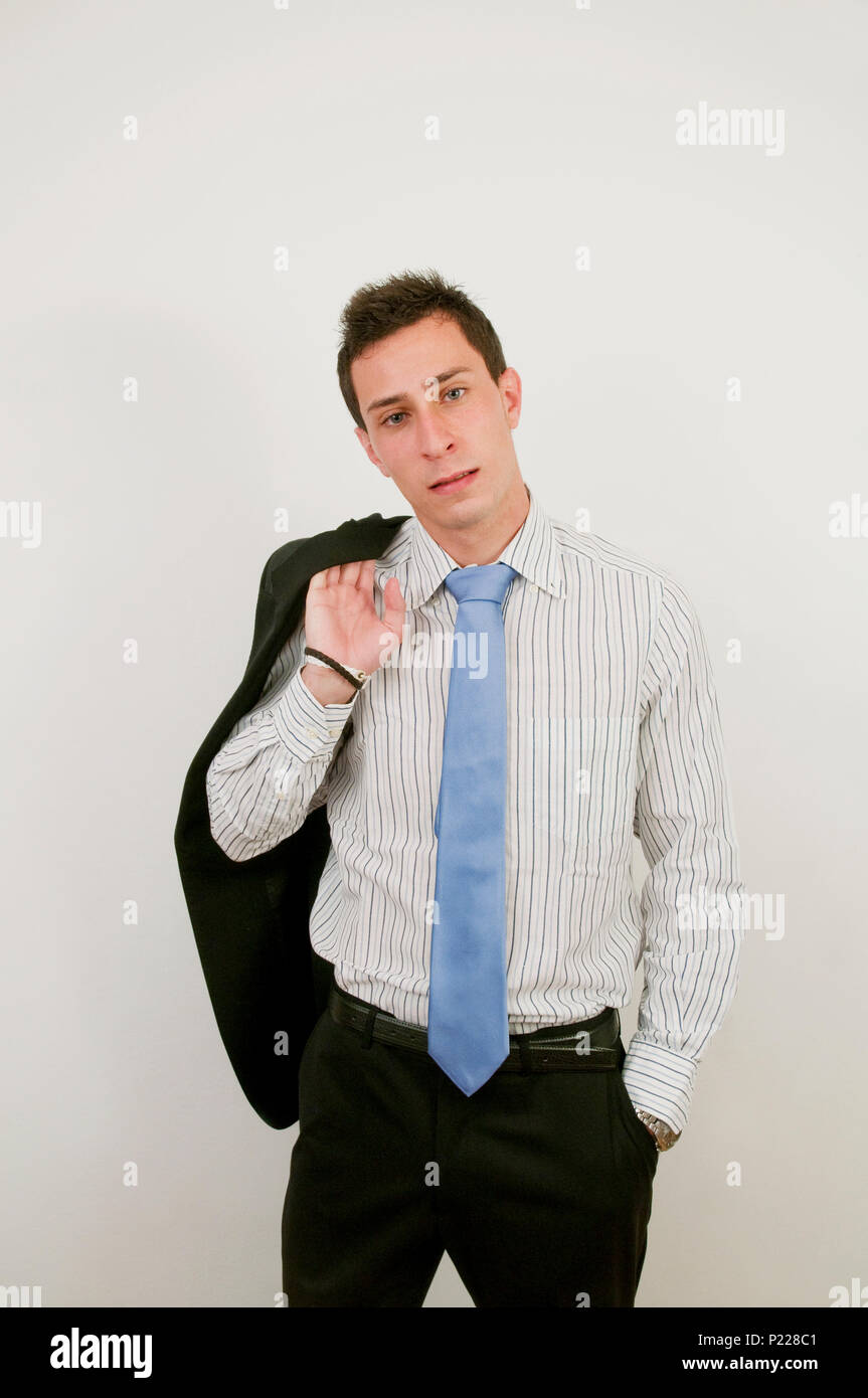 Young executive, jacket on shoulder, looking at the camera. Stock Photo
