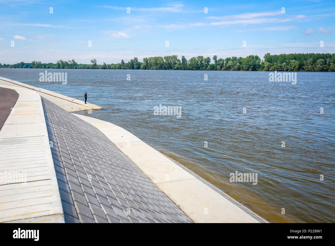 Man standing on a new embankment on the shore of river Danube in Vukovar, Croatia. Danube is Europes second longest river. Stock Photo