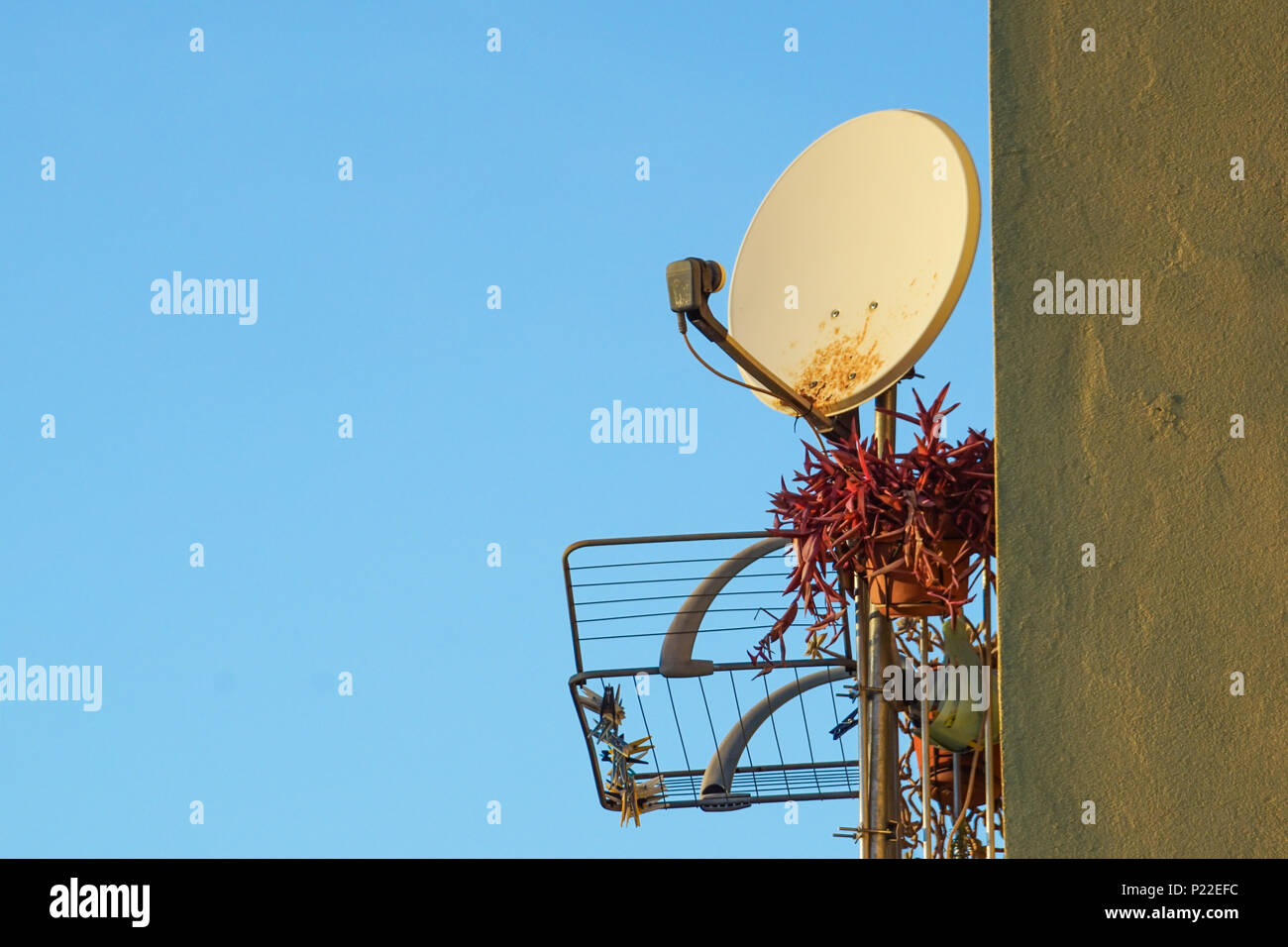 Old rusty satellite antenna on the wall Stock Photo