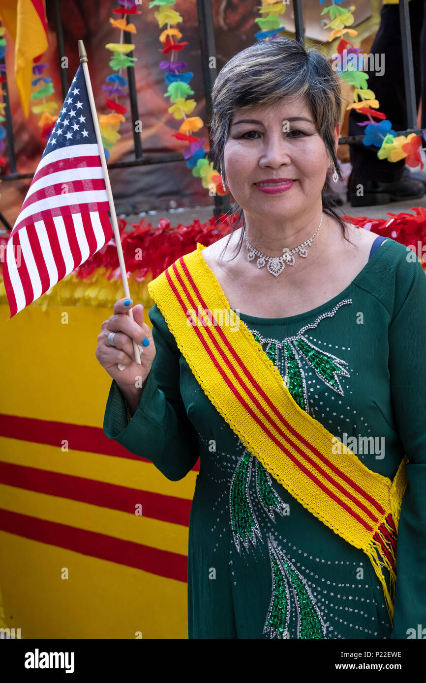 An immigrant wearing a South Vietnam sash waving an American flag at the Vietnamese American Cultural Parade. Stock Photo