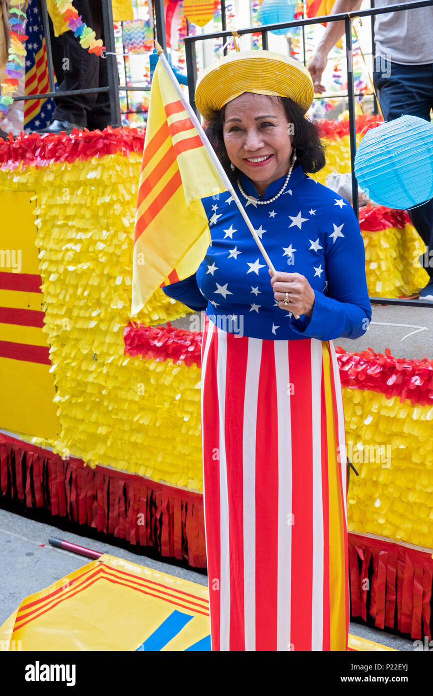 An immigrant wearing a stars and stripes dress and waving a South Vietnamese flag at the Vietnamese American Cultural Parade. Stock Photo