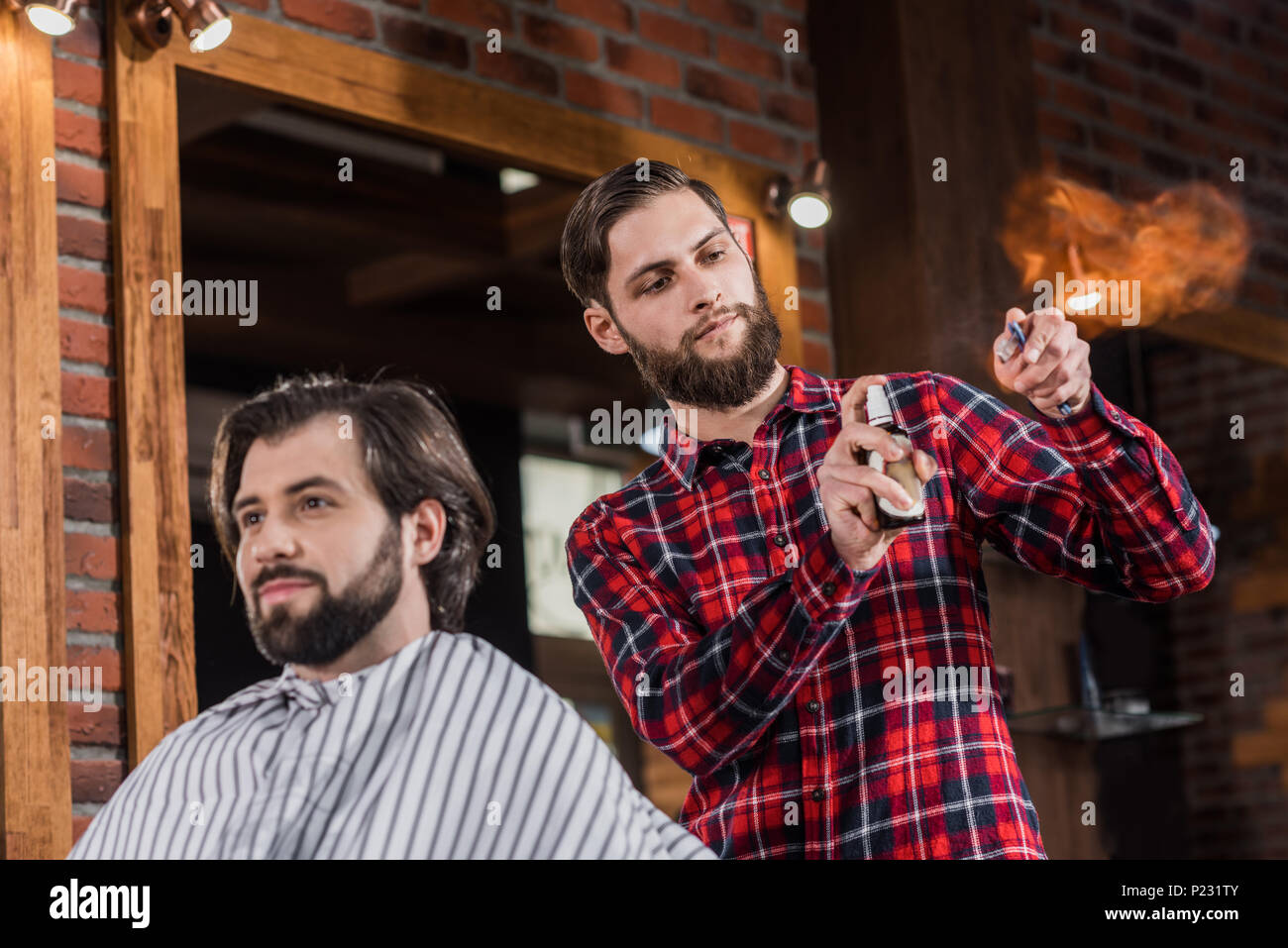 Young Barber Spraying Disinfectant Onto Straight Razor Before