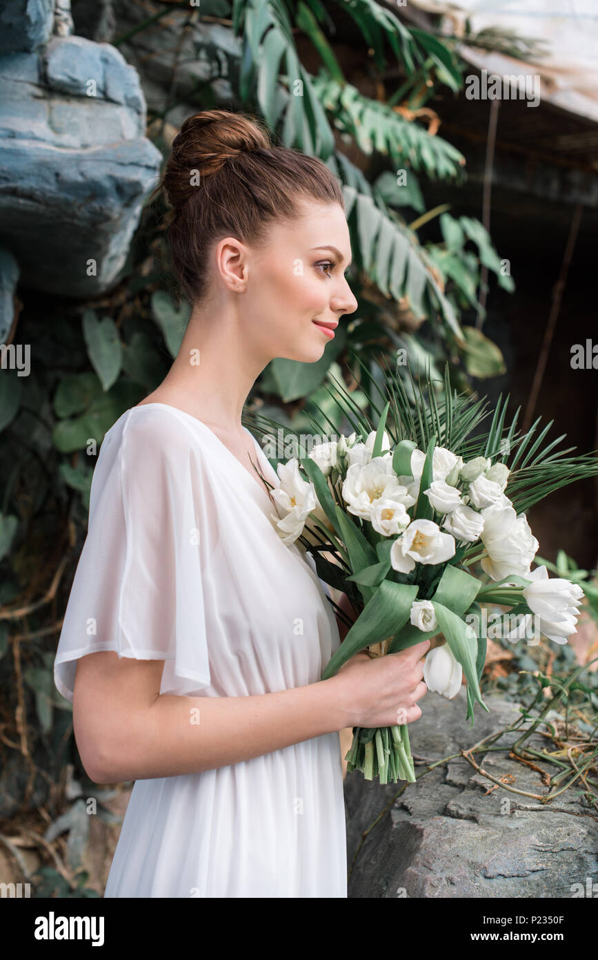 fashionable bride posing in white dress with wedding bouquet Stock ...