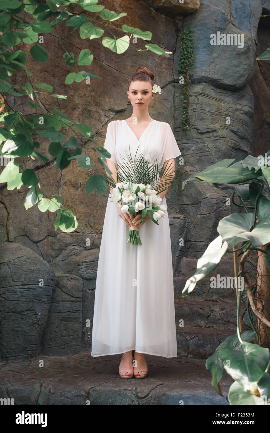attractive bride posing in white dress with wedding bouquet Stock Photo ...