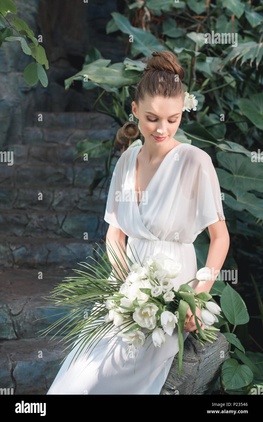attractive bride posing in white dress with wedding bouquet Stock Photo ...