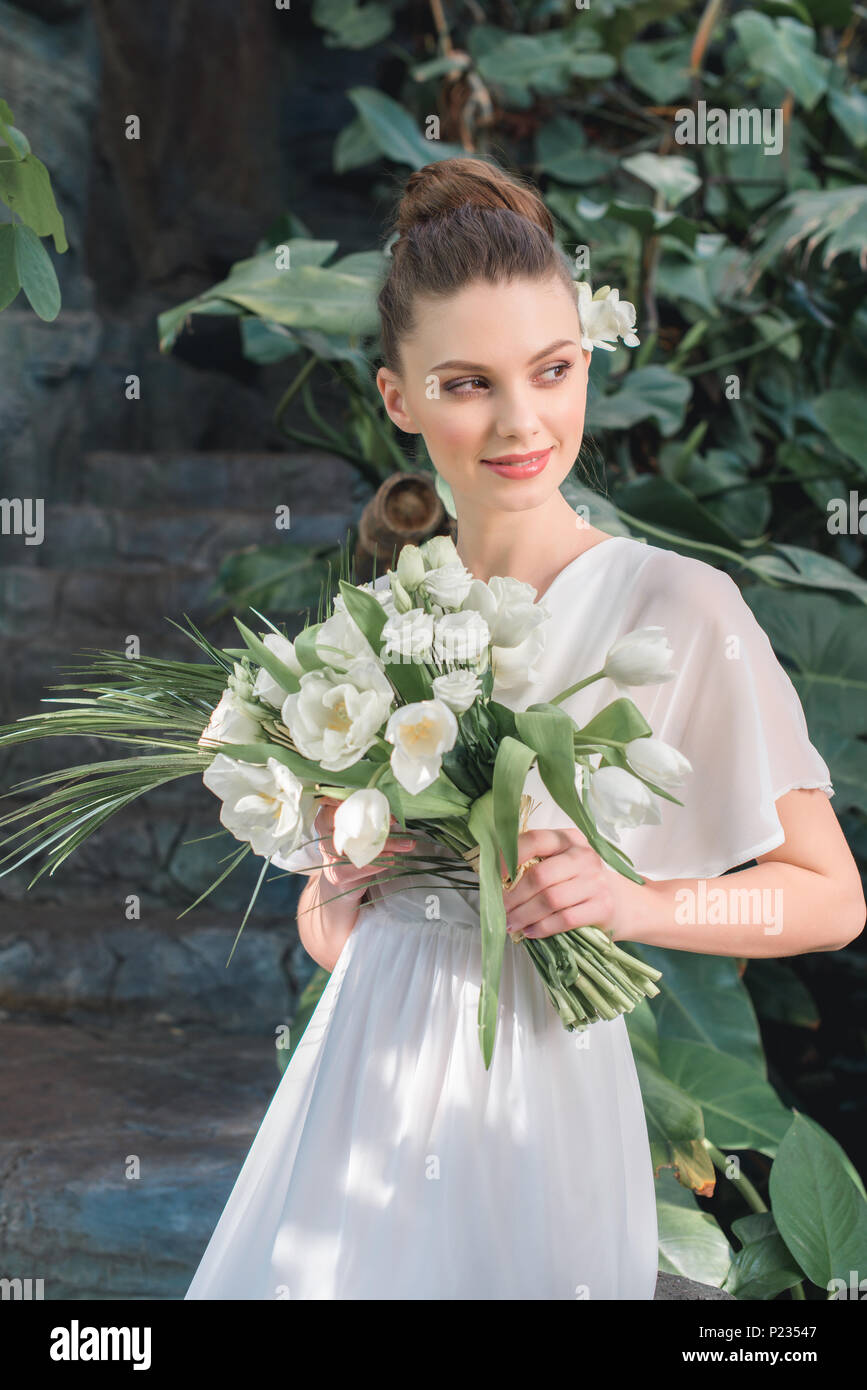 beautiful bride posing in white dress with wedding bouquet Stock Photo ...
