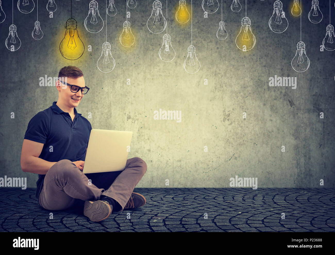 Young smart nerd watching laptop having plenty of great ideas while studying. Stock Photo