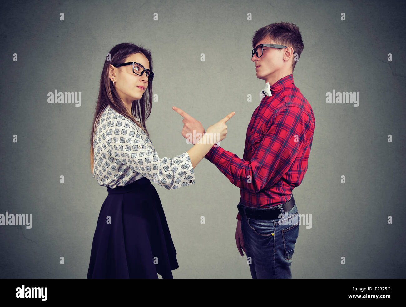Annoyed angry man and woman facing relationships problems, pointing fingers each other blaming for mistakes. Couple in disagreement having argument, c Stock Photo