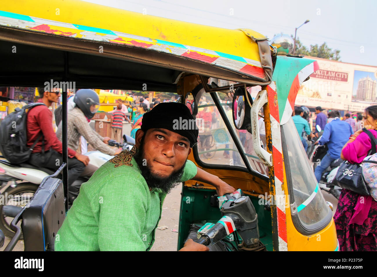 Young man driving tuk-tuk at Kinari Bazaar in Agra, Uttar Pradesh, India. Agra is one of the most populous cities in Uttar Pradesh Stock Photo