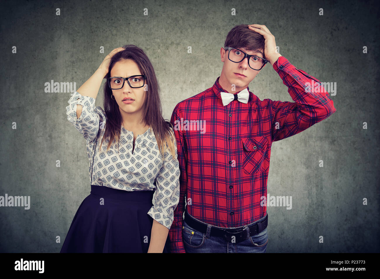 Shocked forgetful couple man and woman holding hands on head and looking at camera with shock and terror Stock Photo
