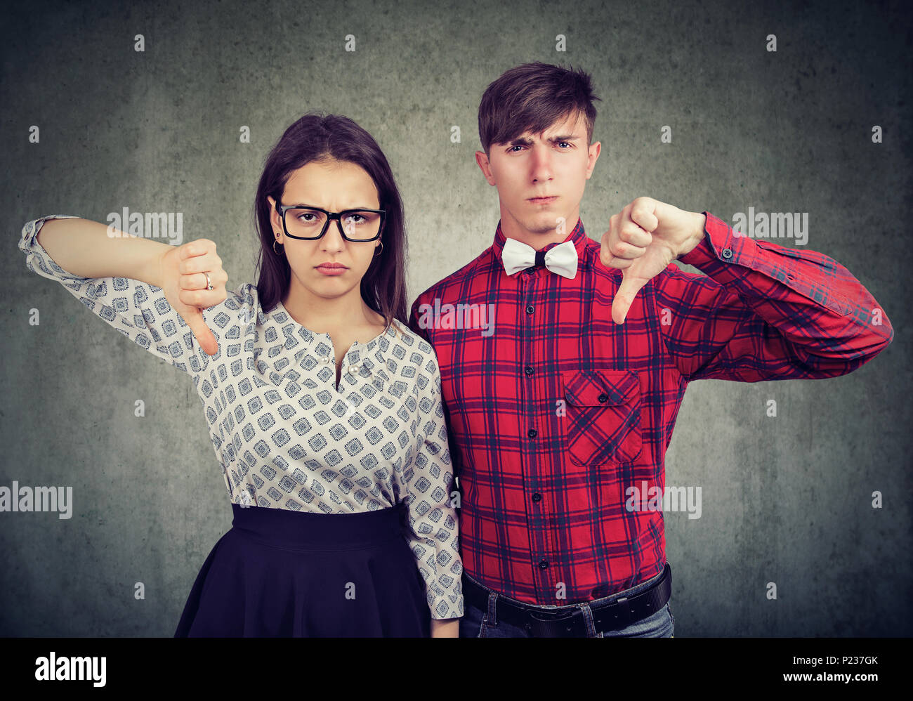 Unhappy grumpy couple giving thumbs down gesture, disagree with ...