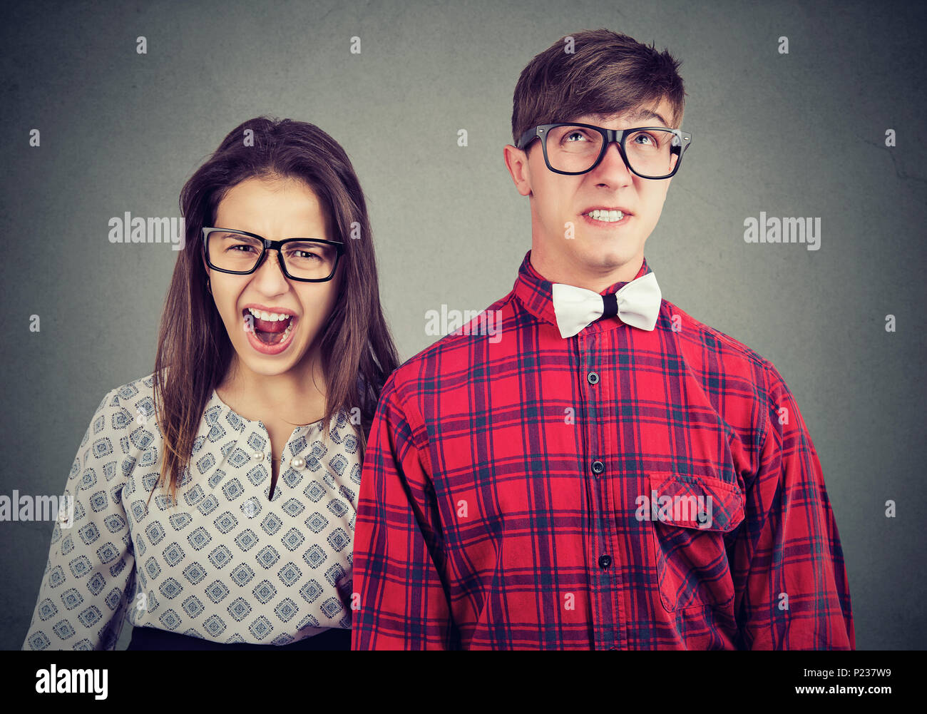 Angry mad woman screaming and fearful annoyed stressed man Stock Photo