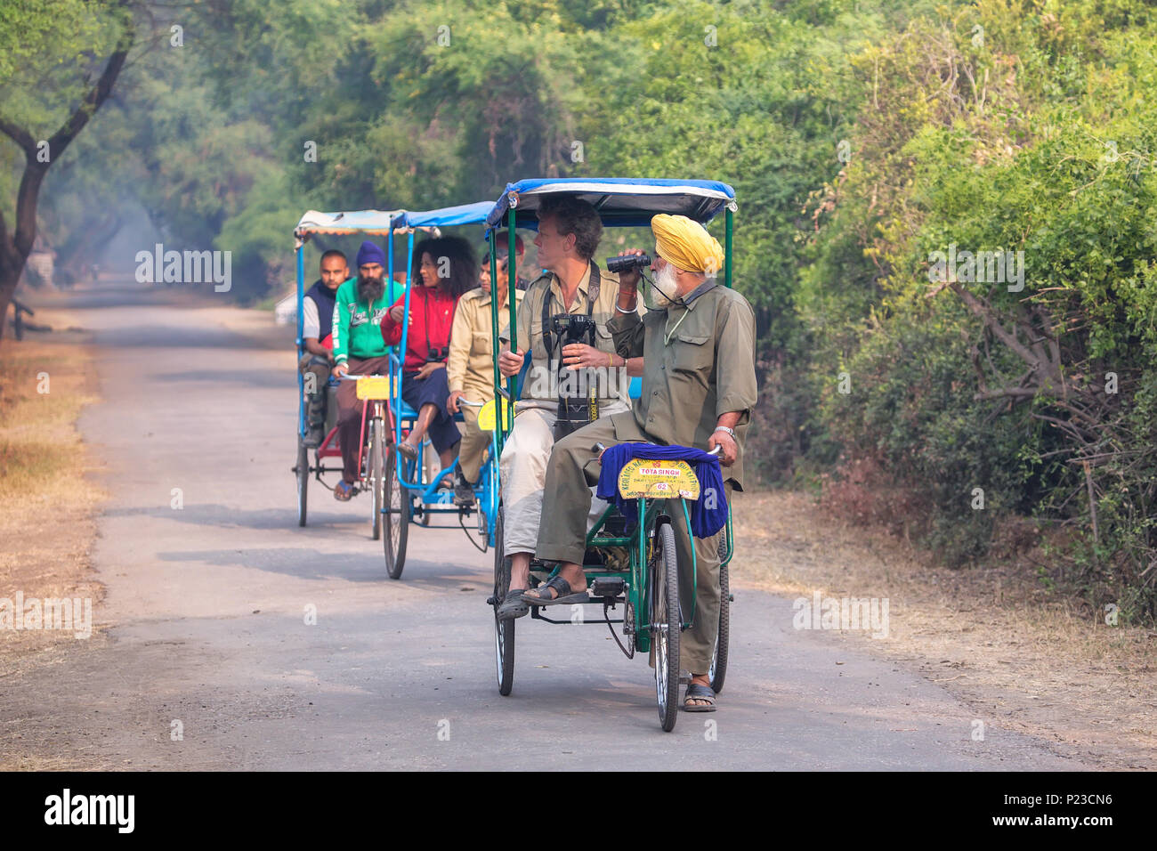 Visitors riding cycle rickshaw in Keoladeo Ghana National Park in Bharatpur, Rajasthan, India. The park was declared a protected sanctuary in 1971 and Stock Photo