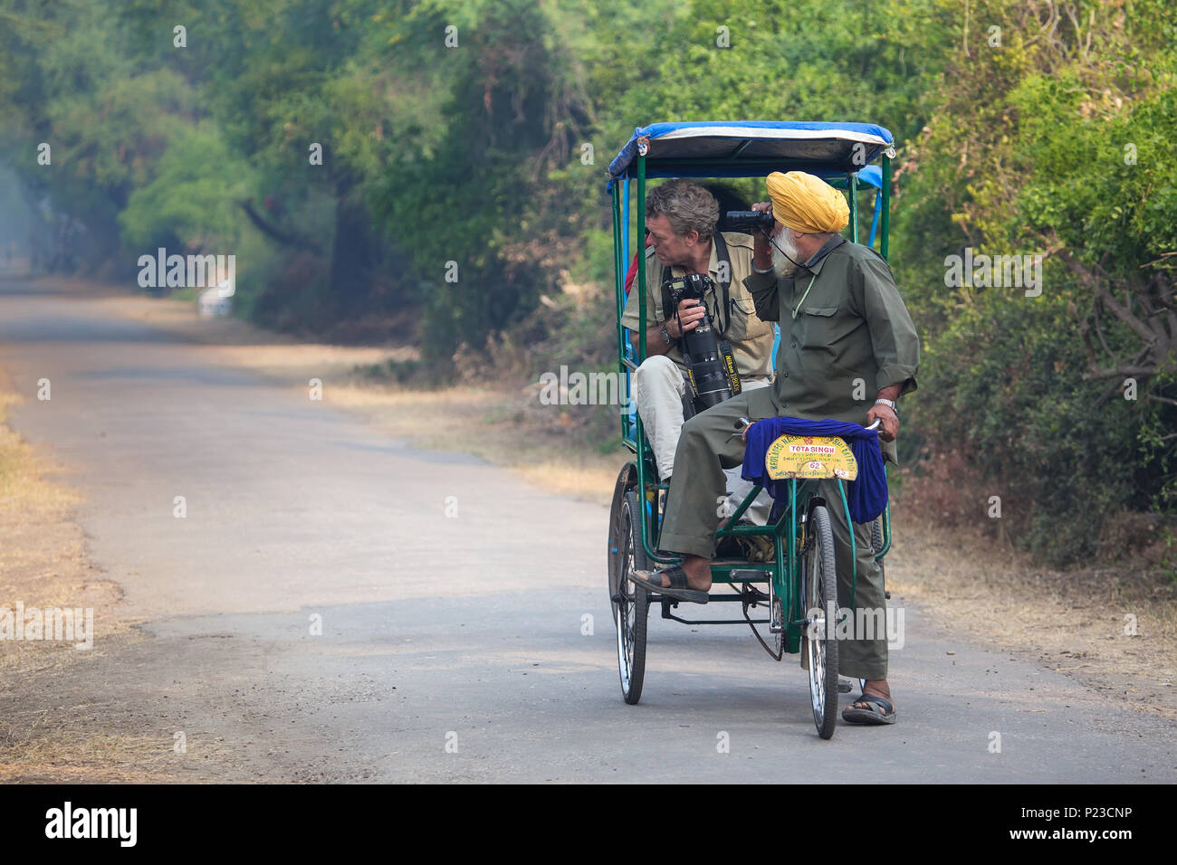 Visitors riding cycle rickshaw in Keoladeo Ghana National Park in Bharatpur, Rajasthan, India. The park was declared a protected sanctuary in 1971 and Stock Photo