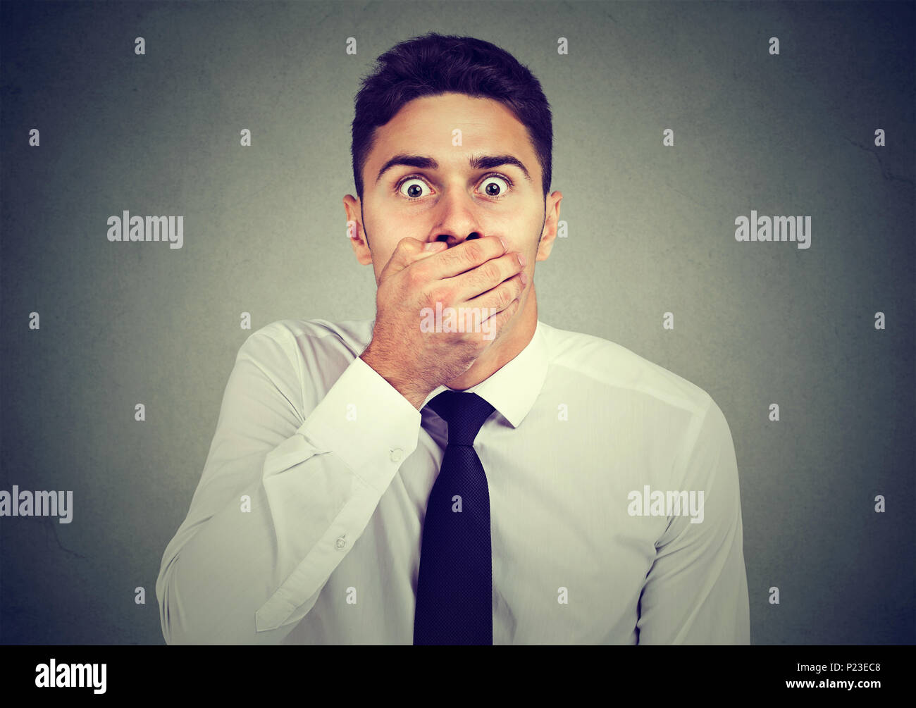 Shocked scared man covering his mouth with his hand Stock Photo