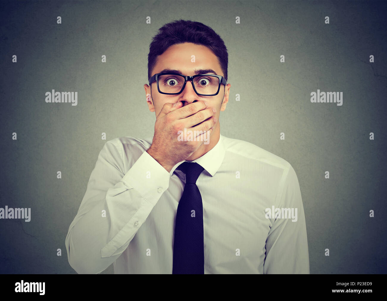 Shocked man covering his mouth with hand Stock Photo