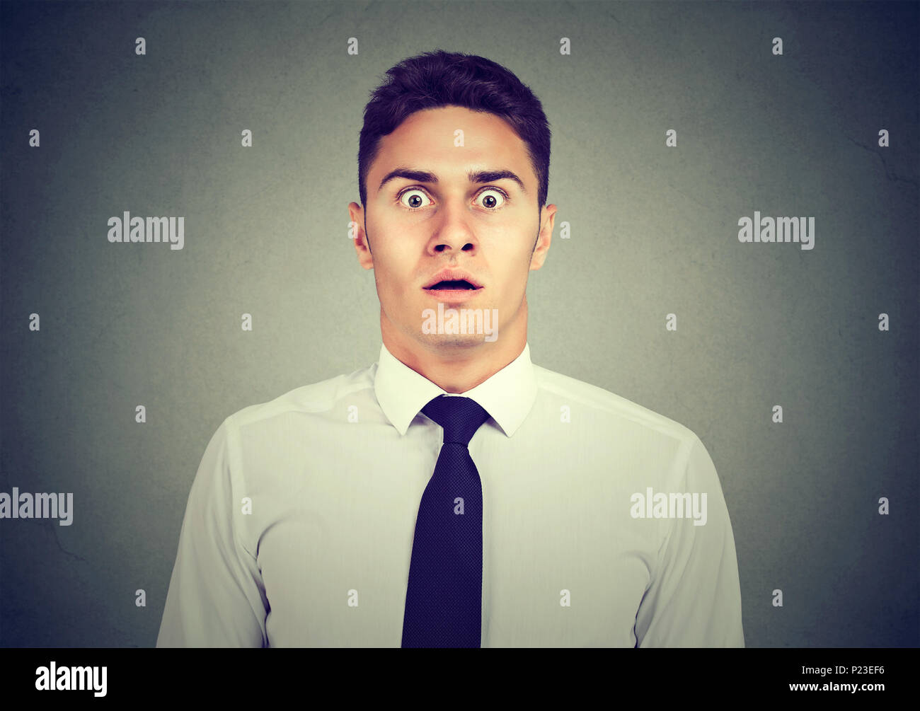 Scared stunned young business man looking at camera Stock Photo