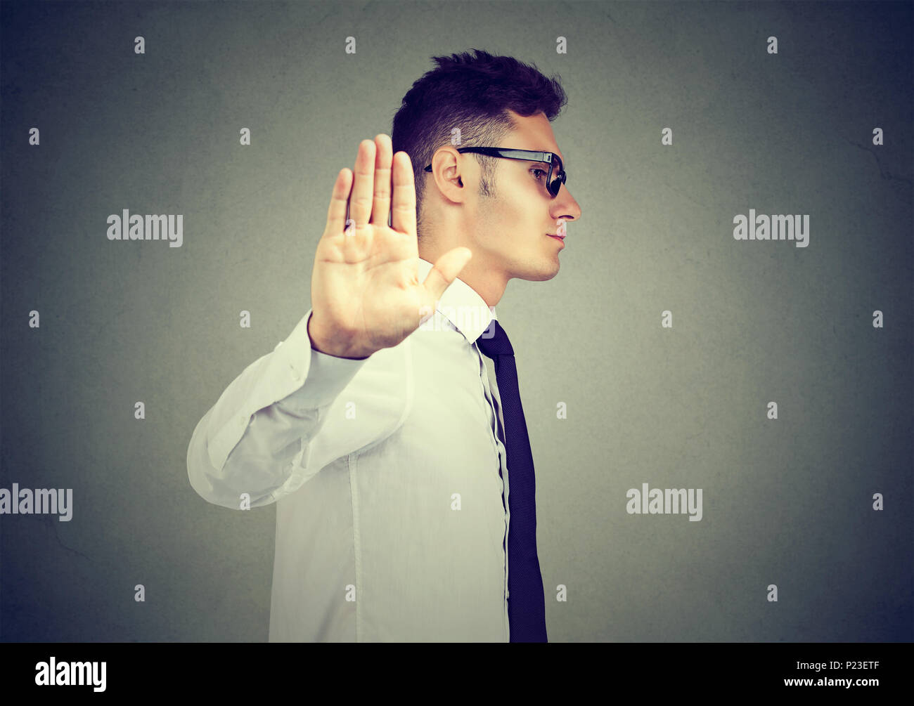 Annoyed angry man with bad attitude giving talk to hand gesture isolated on gray background. Negative human emotion face expression feeling body langu Stock Photo