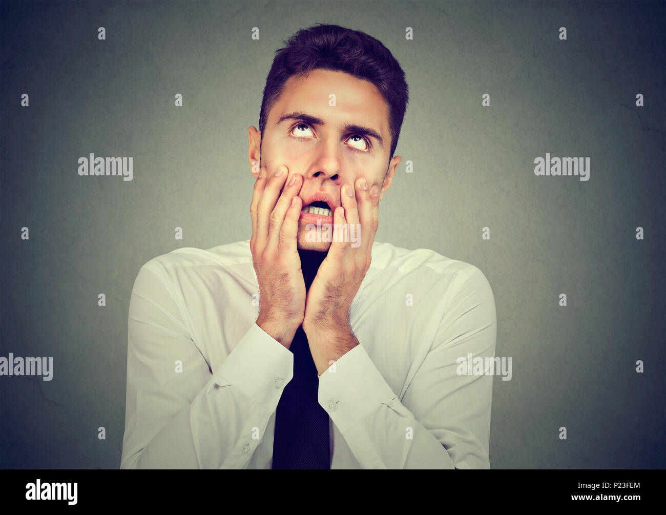 Desperate young business man isolated on gray background Stock Photo