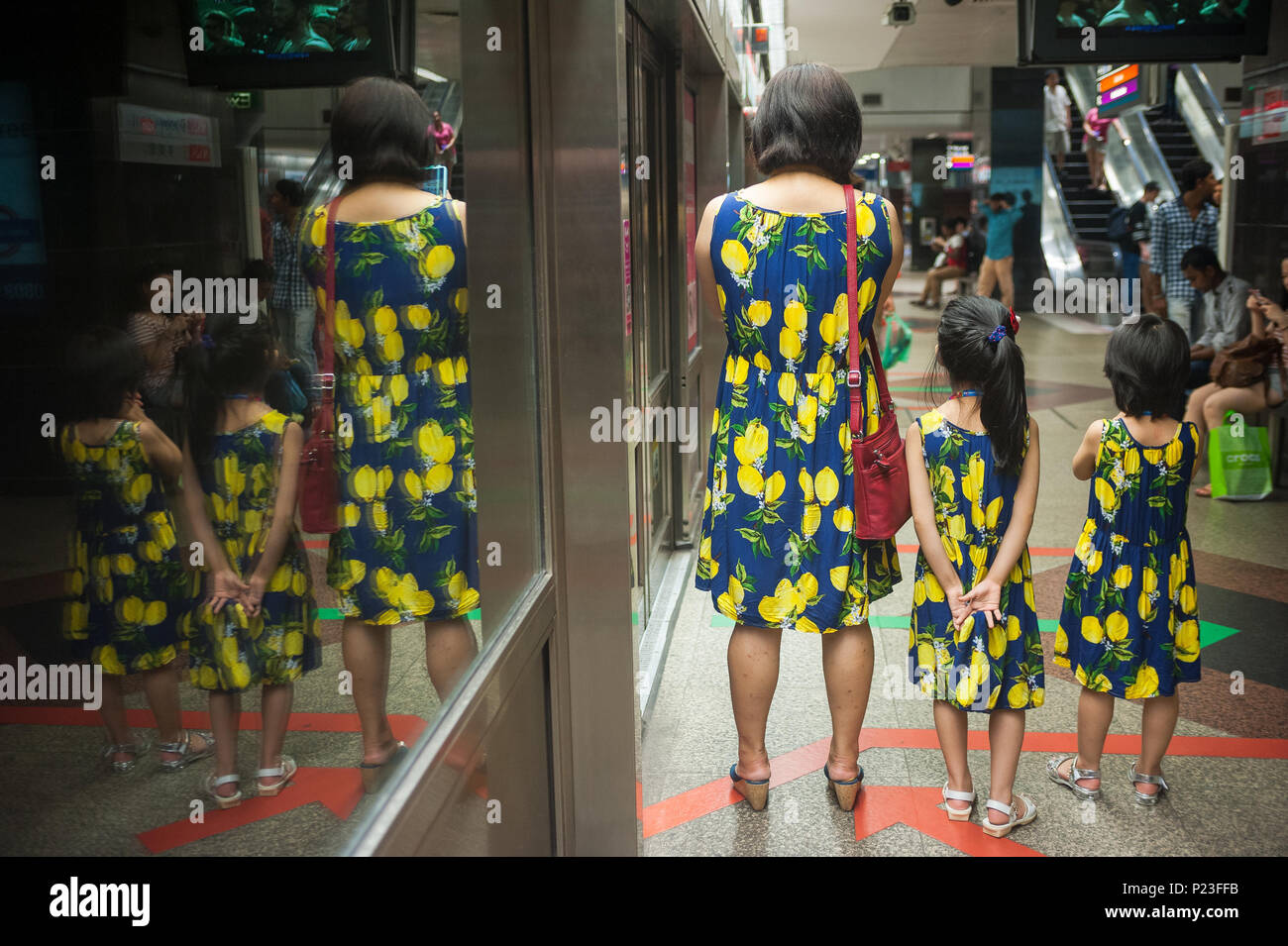 Singapore, Singapore, mother waiting with her daughters on the subway