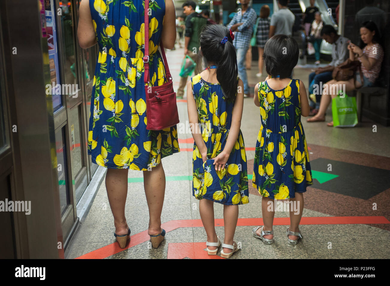 Singapore, Singapore, mother waiting with her daughters on the subway
