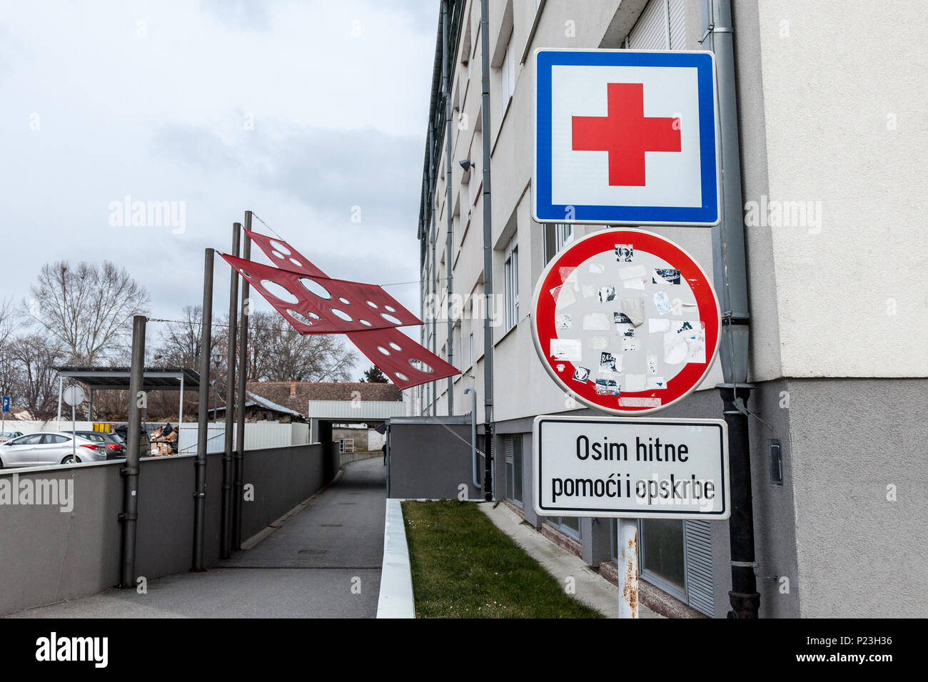 VUKOVAR, CROATIA - FEBRUARY 25, 2018: Entrance of the Vukovar Hospital memorial with its iconic red cross, a memorial dedicated to the massacre that o Stock Photo