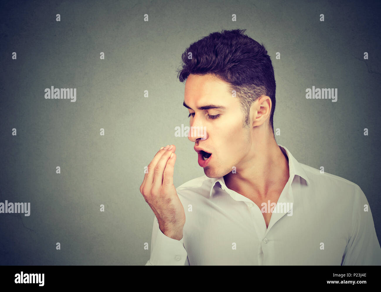 Young man checking his breath with hand. Stock Photo