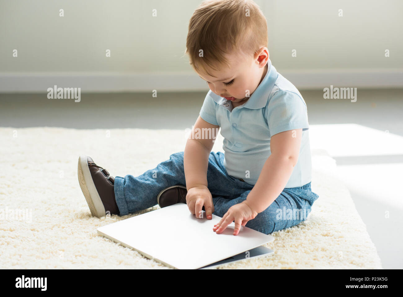 little baby boy with laptop sitting on floor at home Stock Photo - Alamy