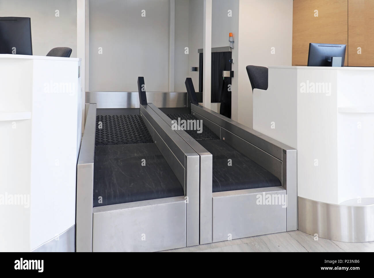 Baggage drop off counter on airport with empty conveyer and counter