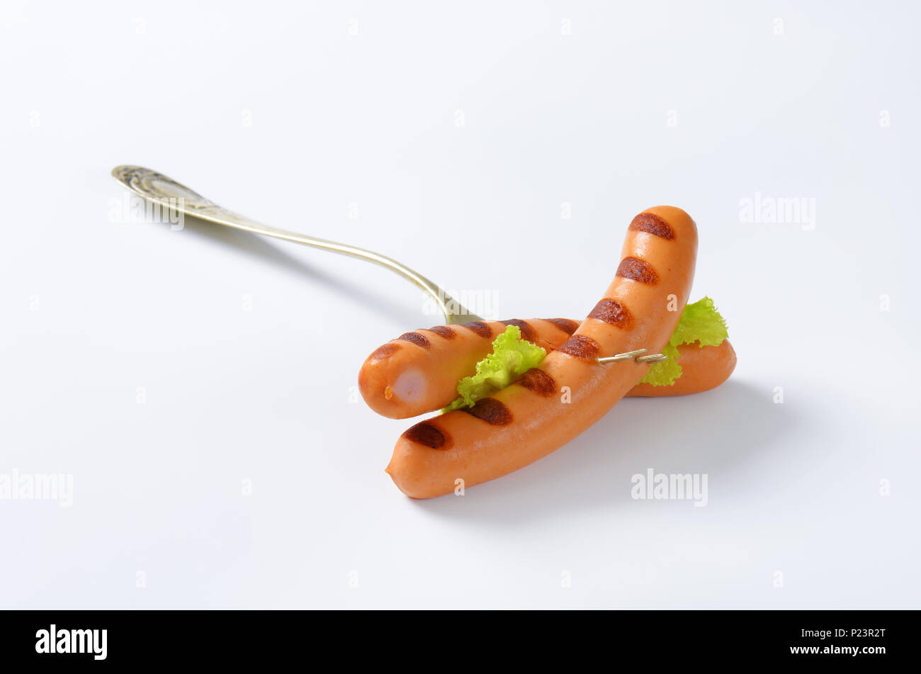 grilled wiener sausages impaled on fork Stock Photo