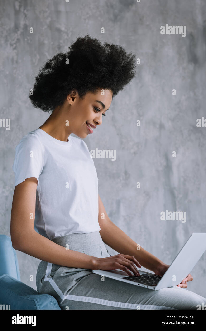 African american girl using laptop while sitting on sofa Stock Photo ...