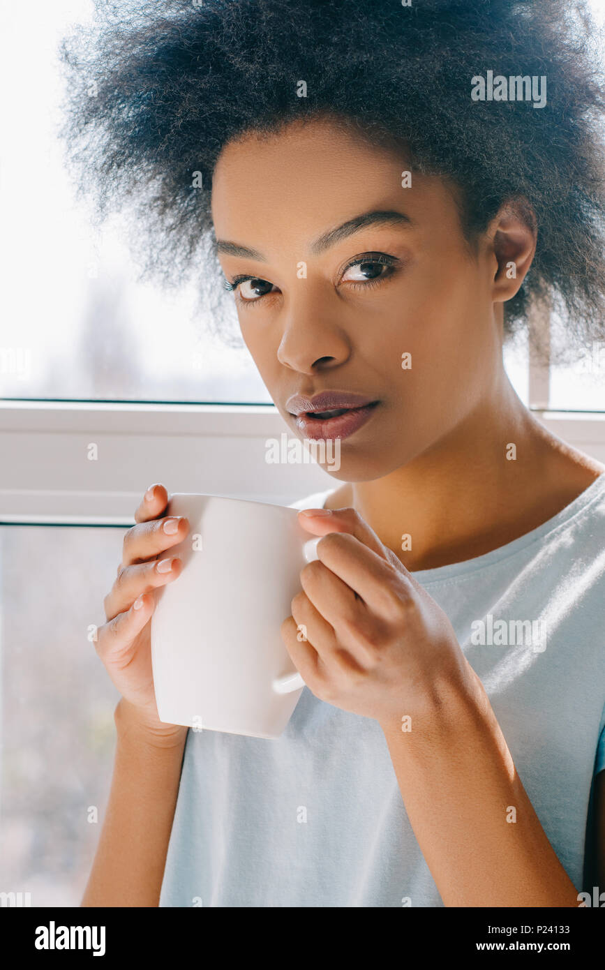 African american girl in lounge wear drinking coffee from cup Stock ...