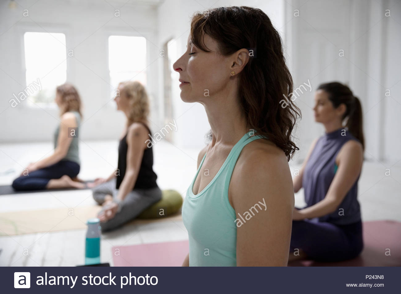 Serene woman meditating in yoga class Stock Photo - Alamy