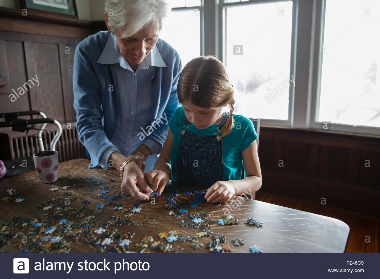 Grandmother and granddaughter assembling jigsaw puzzle Stock Photo