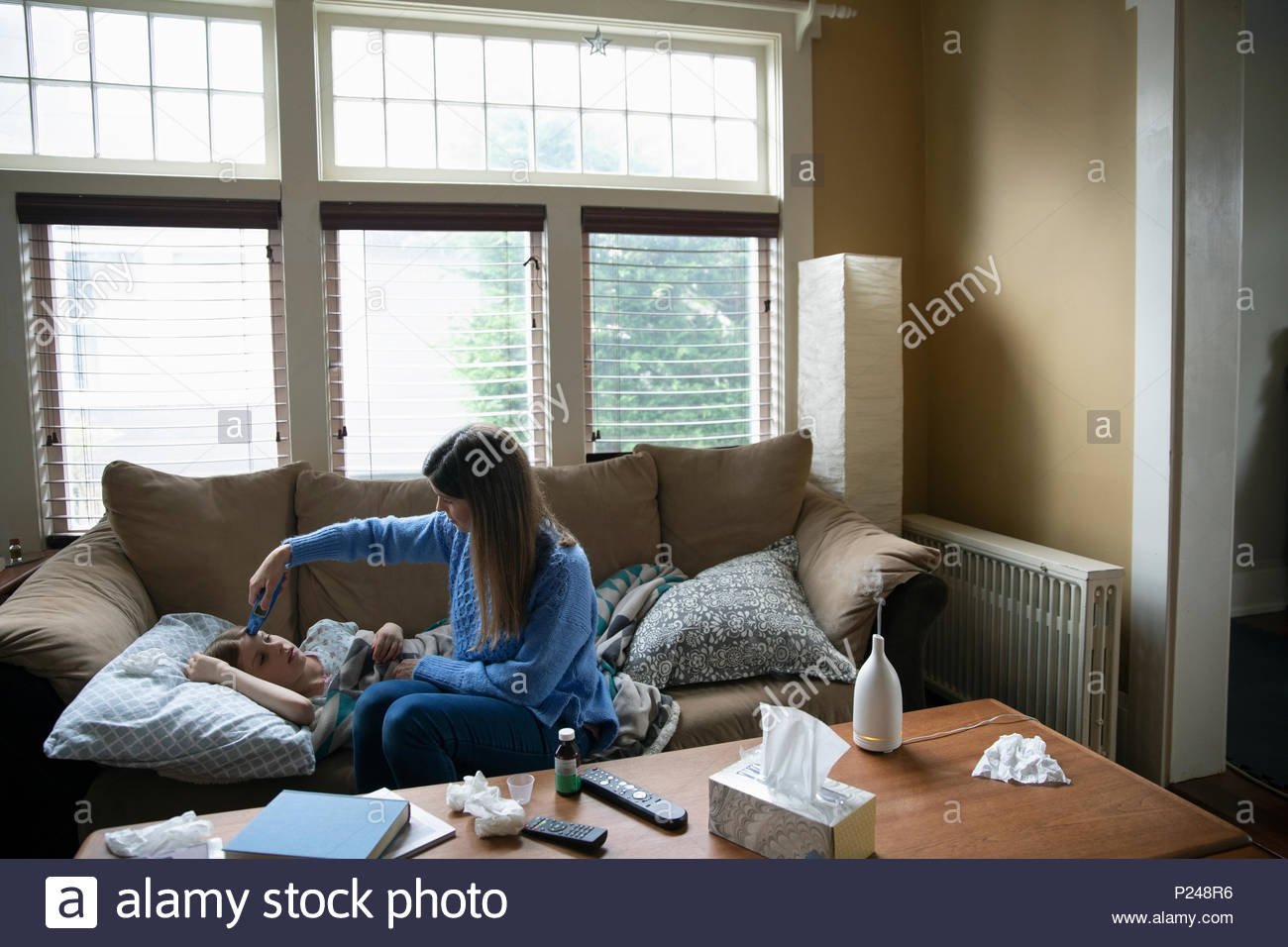 Mother Using Thermometer To Check Temperature Of Sick