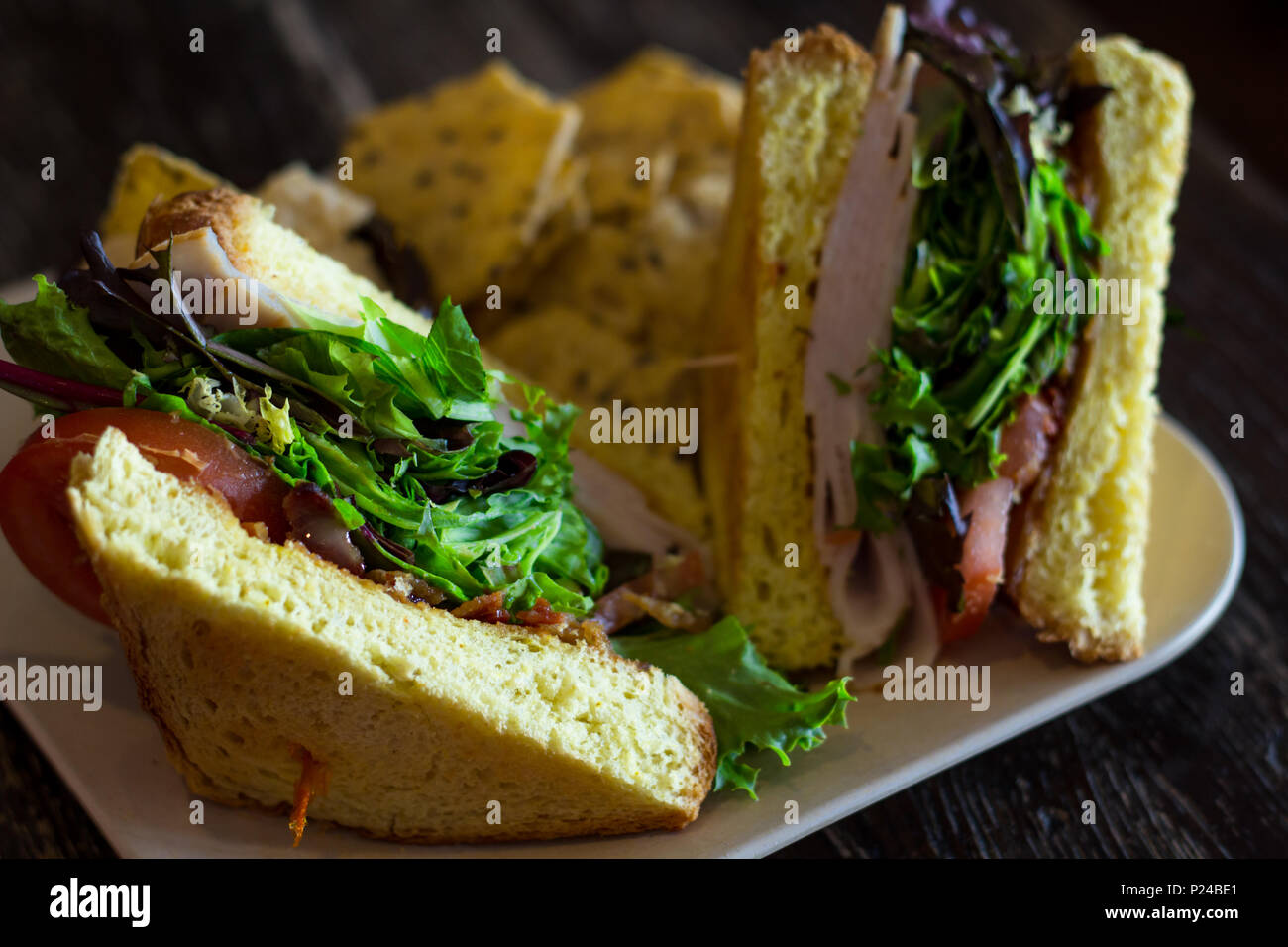 Turkey BLT sandwich on texas toast with sesame seed chips and hummus