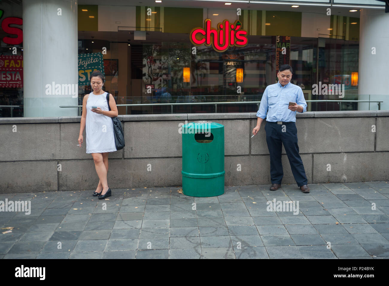Singapore, Singapore, people smoking in front of a shopping center