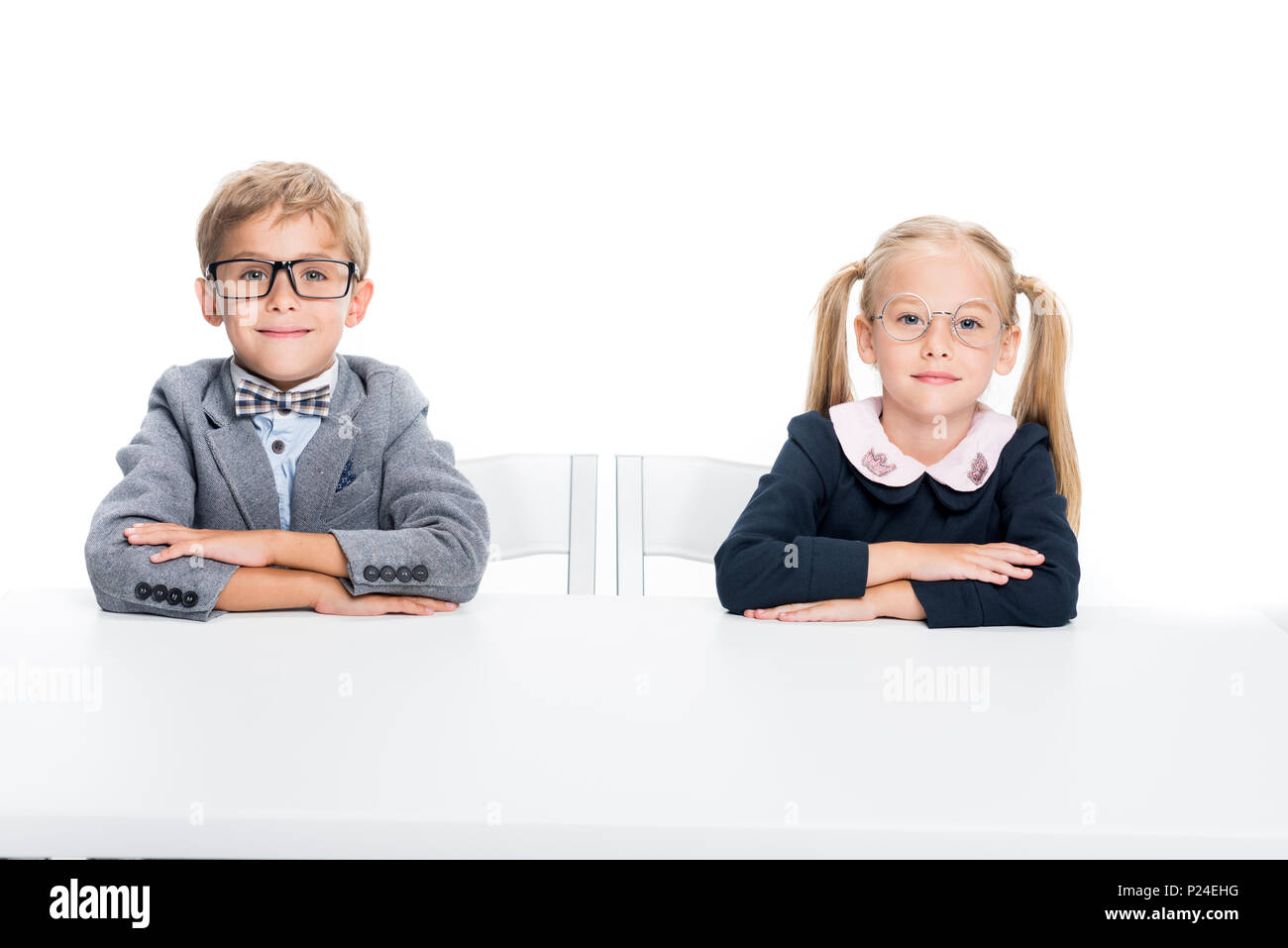 adorable pupils sitting at desk isolated on white Stock Photo - Alamy