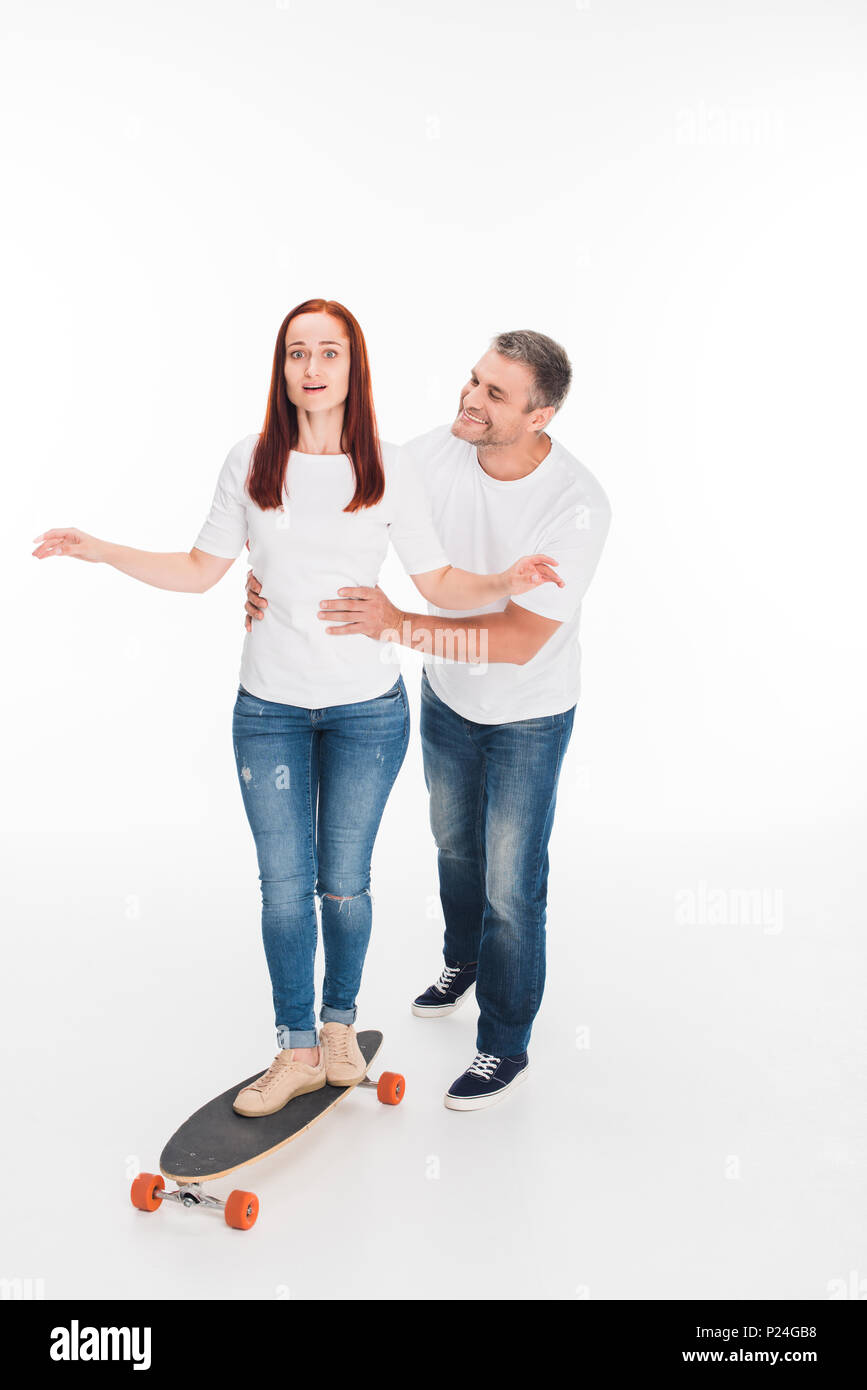 scared female skateboarder on longboard with girlfriend near, isolated