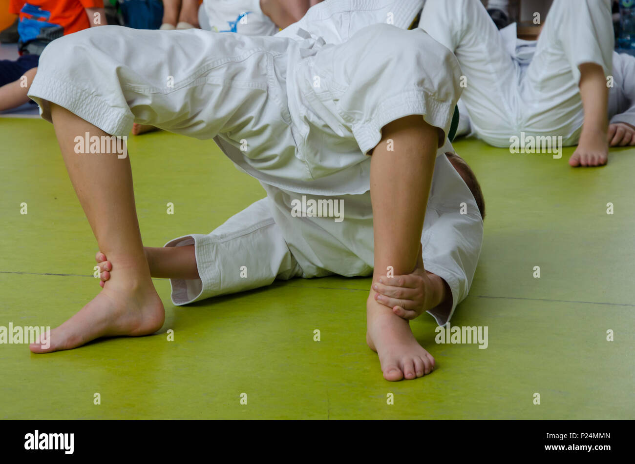 A boy in the kimono practicing karate on the floor in the gym Stock Photo