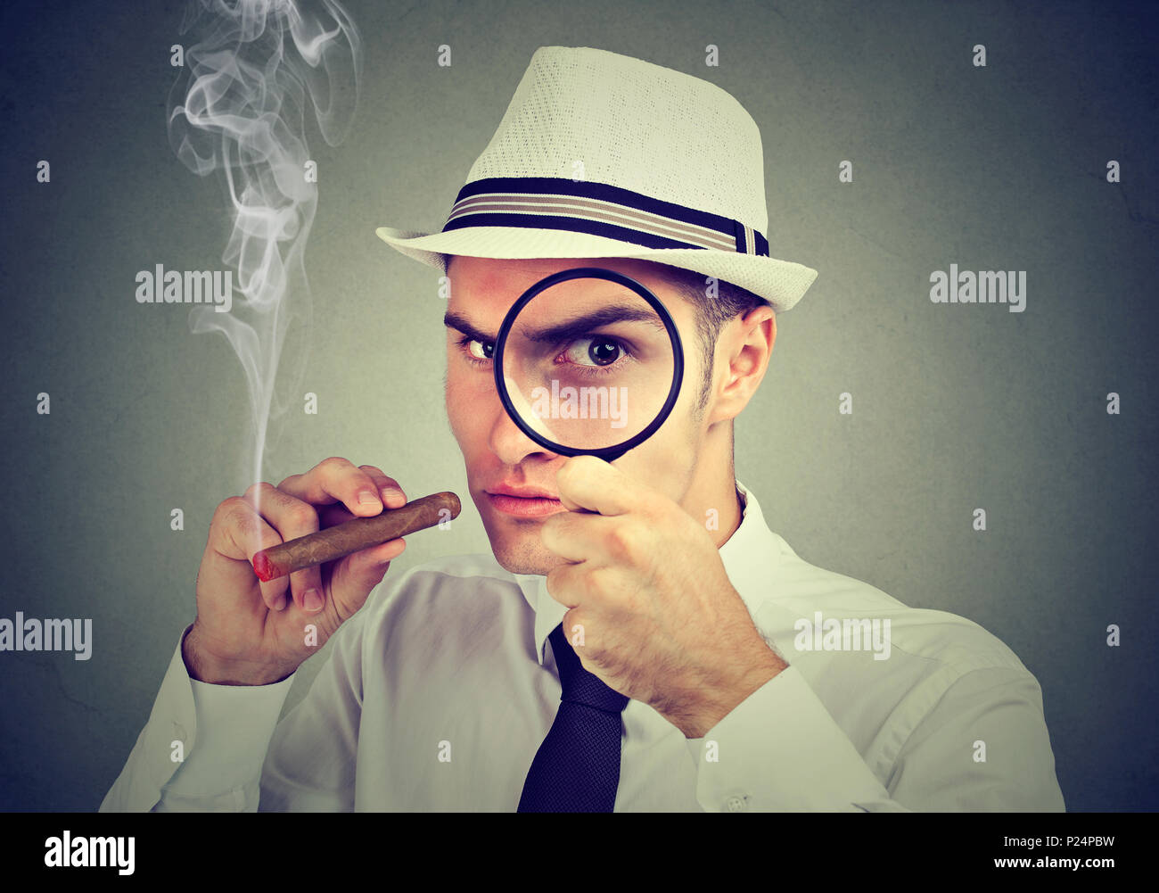 Investigator man looking through magnifying glass Stock Photo