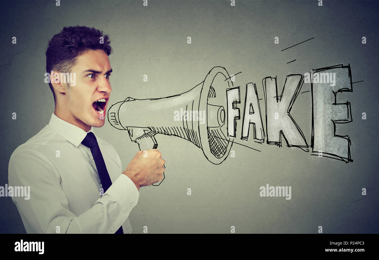 Business man screaming in a megaphone spreading fake news Stock Photo