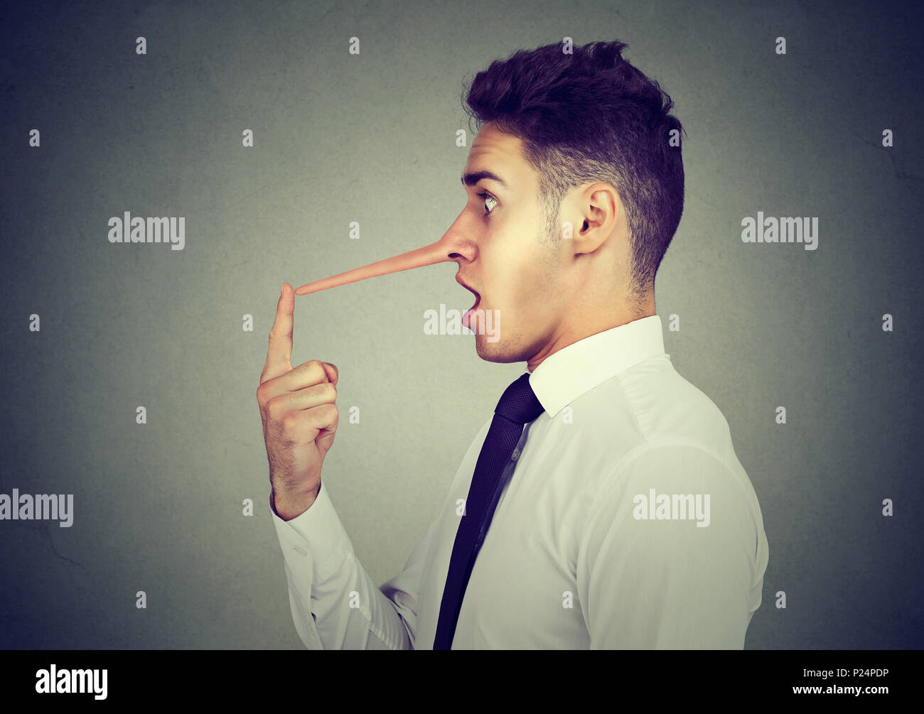 Business man with long nose isolated on grey wall background. Liar concept. Stock Photo