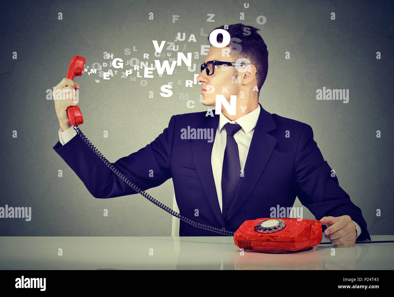Business man looking at telephone handset with alphabet letters flying out Stock Photo